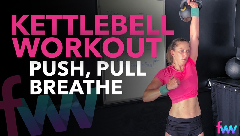 Kindal extending the kettlebell over her head during a clean to press.