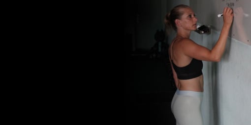 Kindal writing a workout on the whiteboard.